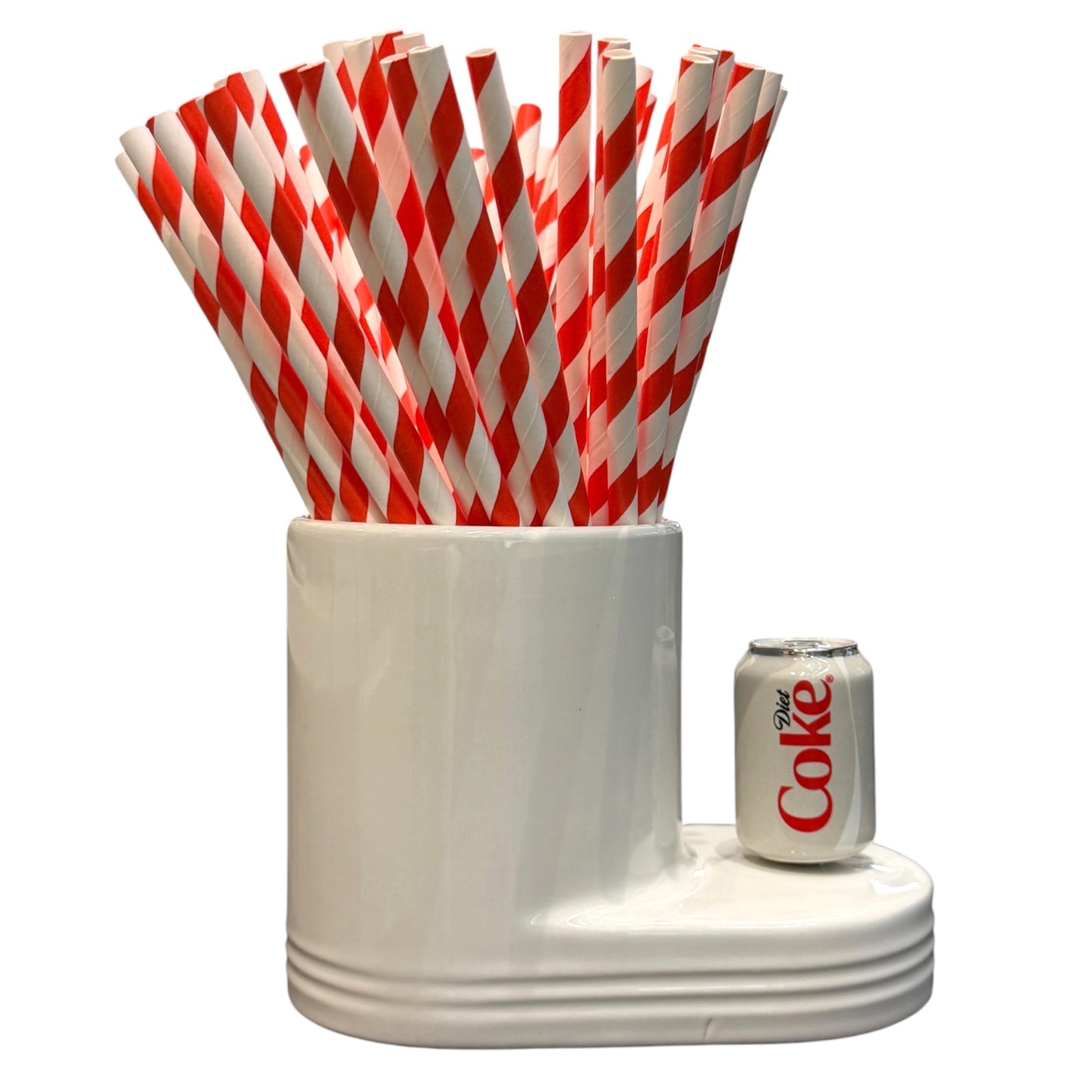 White holder with red and white striped straws and a Coca-Cola can on a white background
